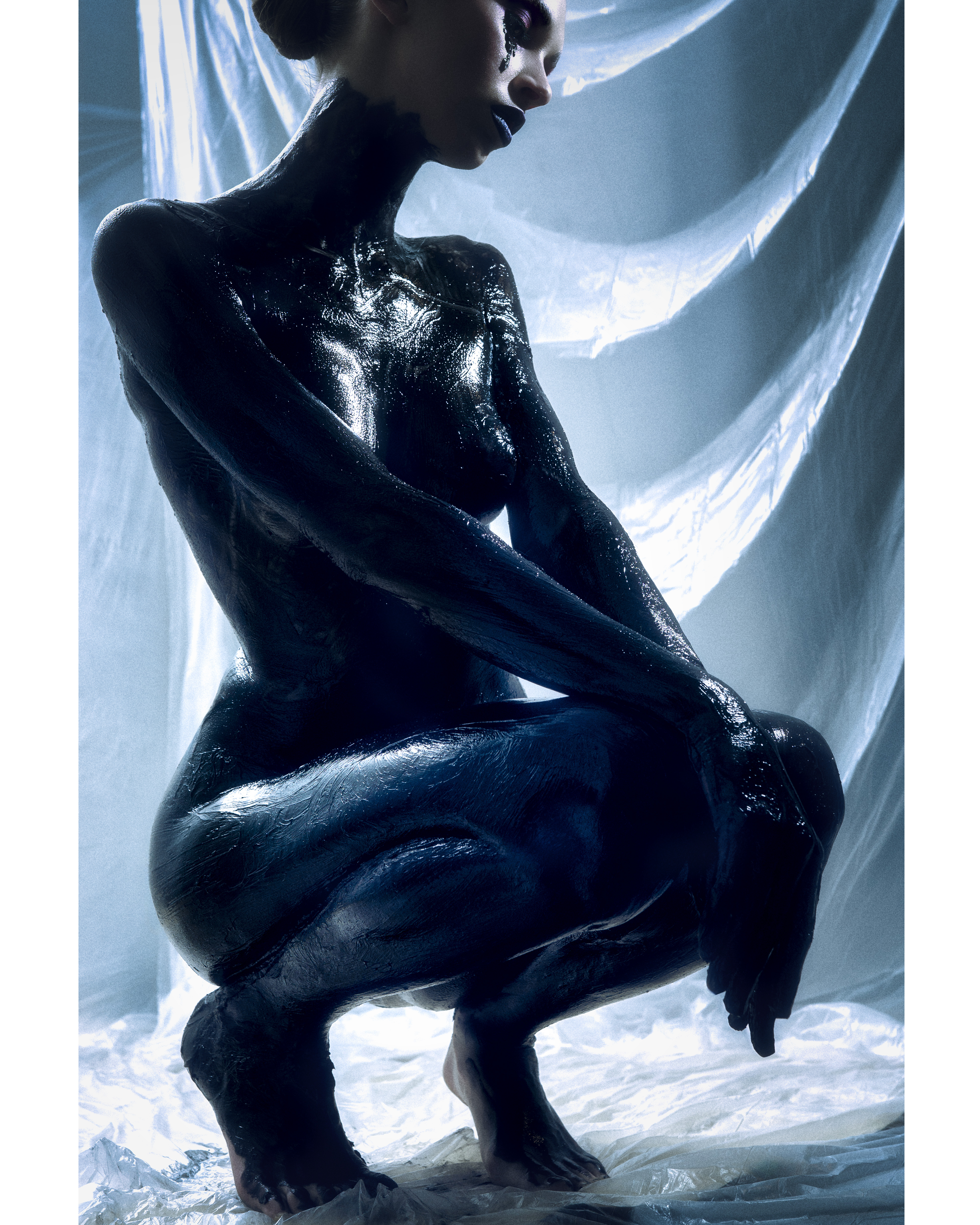 conceptual fine art photography — full body figure covered in black paint backlit against white plastic film, Black Gold series, Daniyar Sadykov Toronto