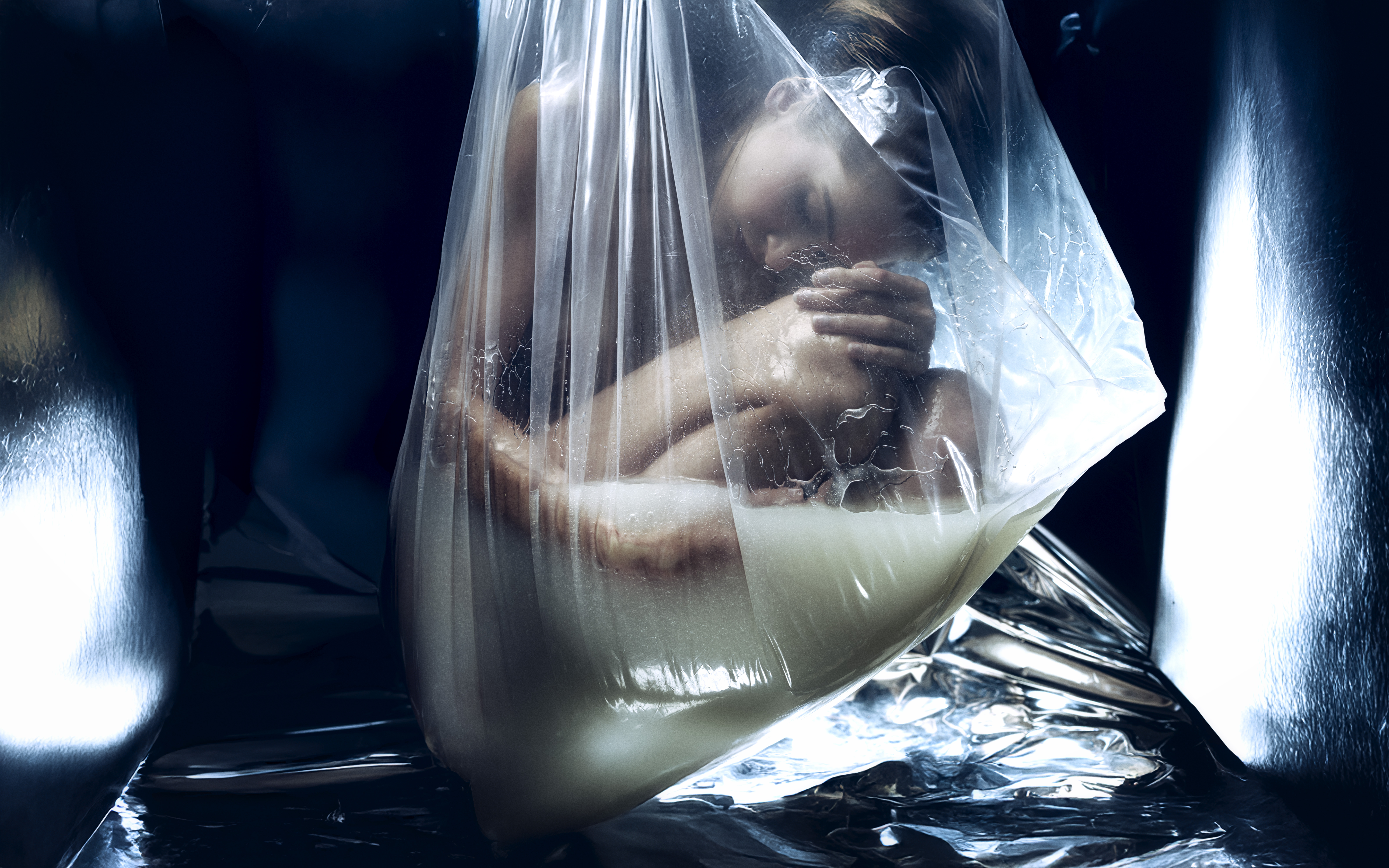 conceptual fine art photography Toronto — figure enclosed in transparent plastic bag with liquid, synthetic womb series by Daniyar Sadykov