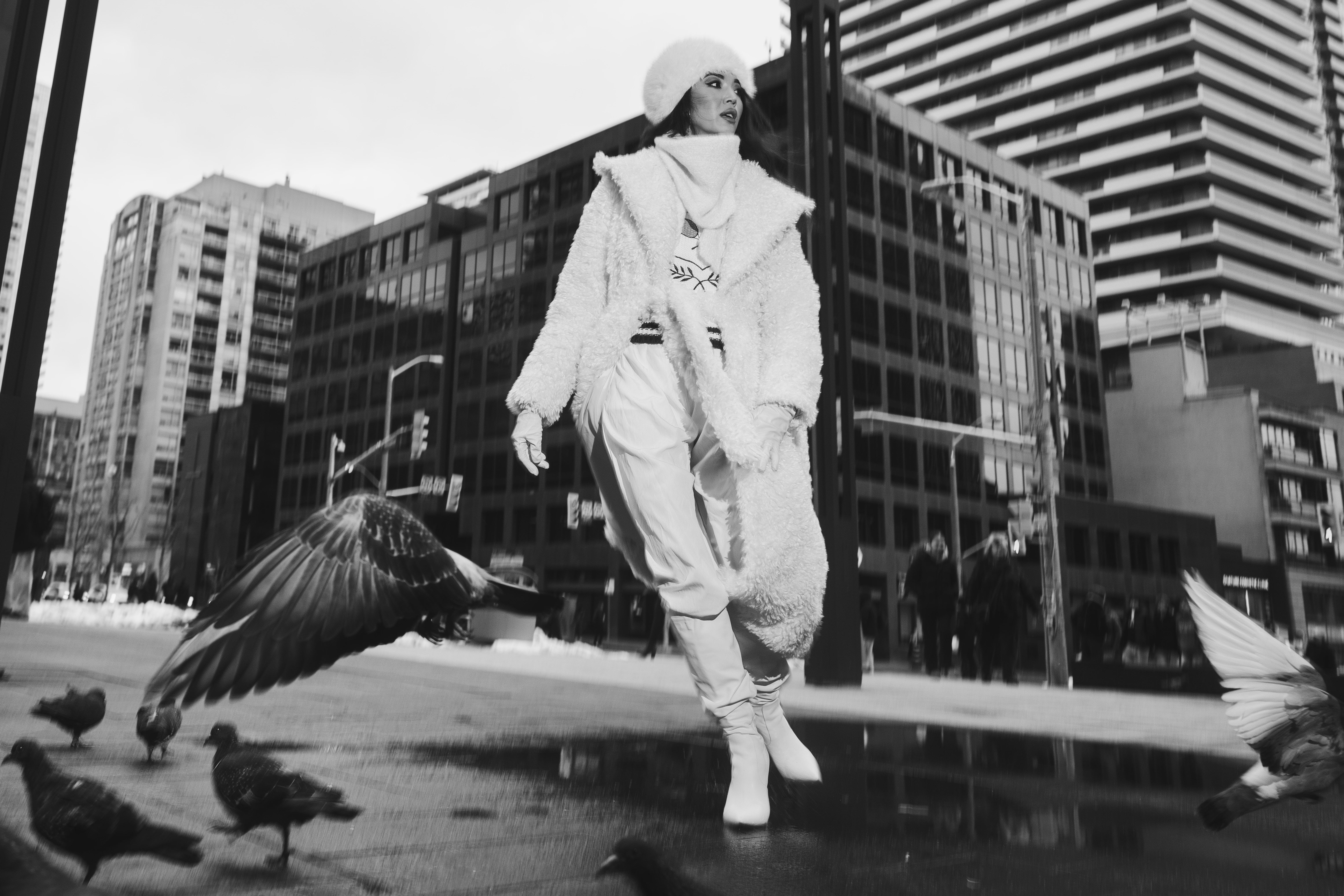 editorial fashion photography Toronto street — model in white fur coat surrounded by pigeons in Financial District, black and white, Love Letters to Toronto by Daniyar Sadykov